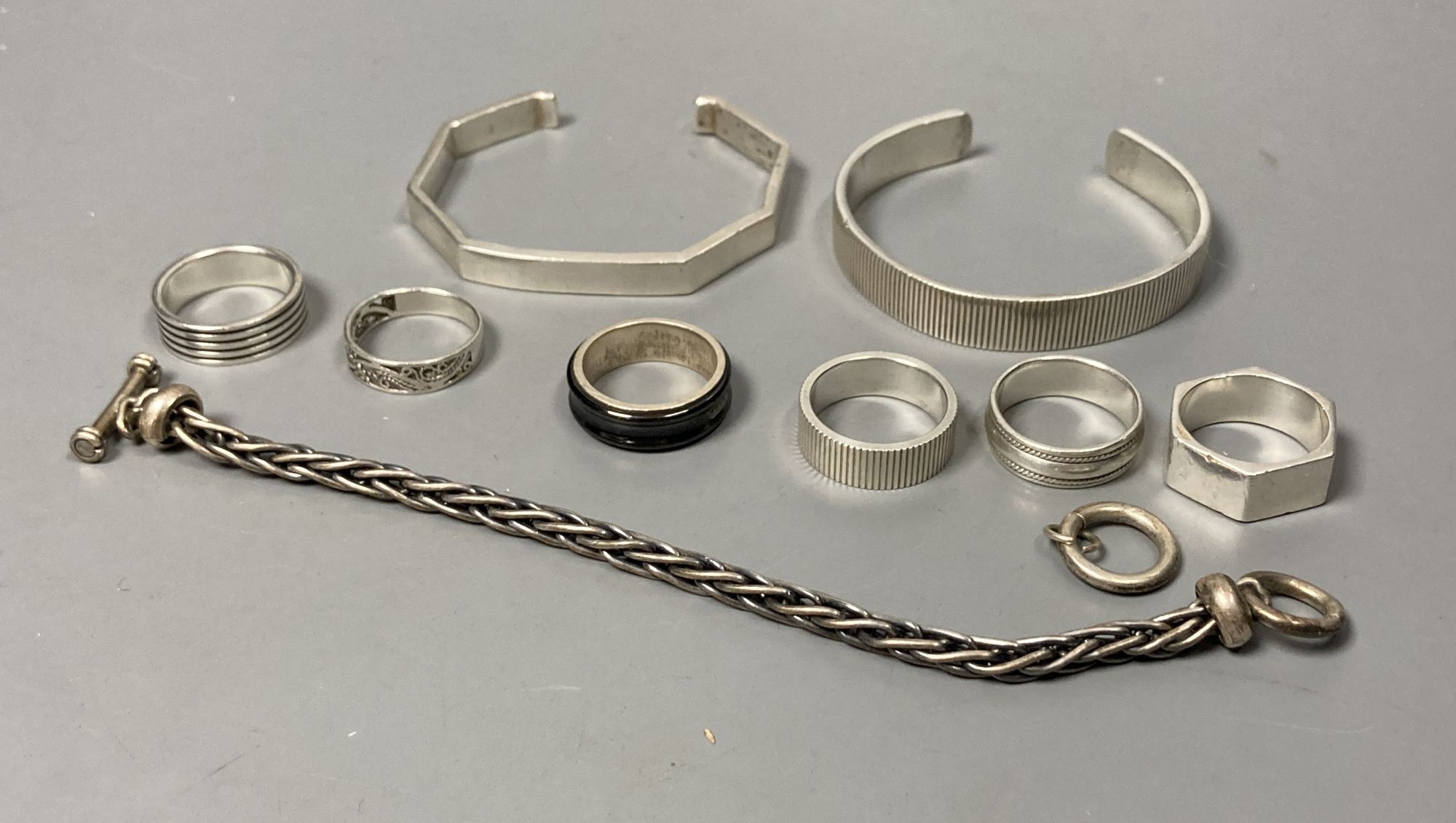 Two white metal bangles, one stamped Tiffany & Co with similar ring, five 925 rings, and a 925 bracelet.